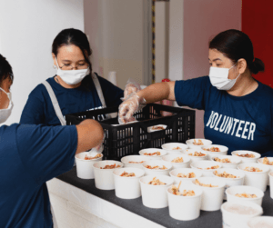 Image of volunteers giving out baked goods for a bake sale fundraising event